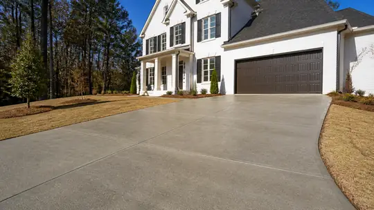colored concrete installation completed by a local contractor at a grey split-level home in Bowling Green, KY, at blue hour.