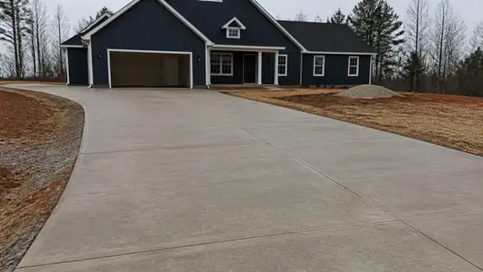 concrete installation completed by a local contractor at a brick-and-siding two-story home in Bowling Green, KY, under bright midday cloud.