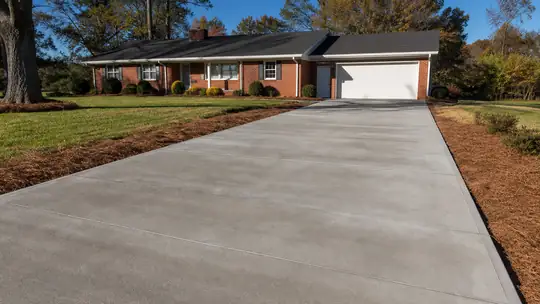 concrete slab repair completed by a local contractor at a painted-white-brick two-story home in Bowling Green, KY, in late afternoon light.